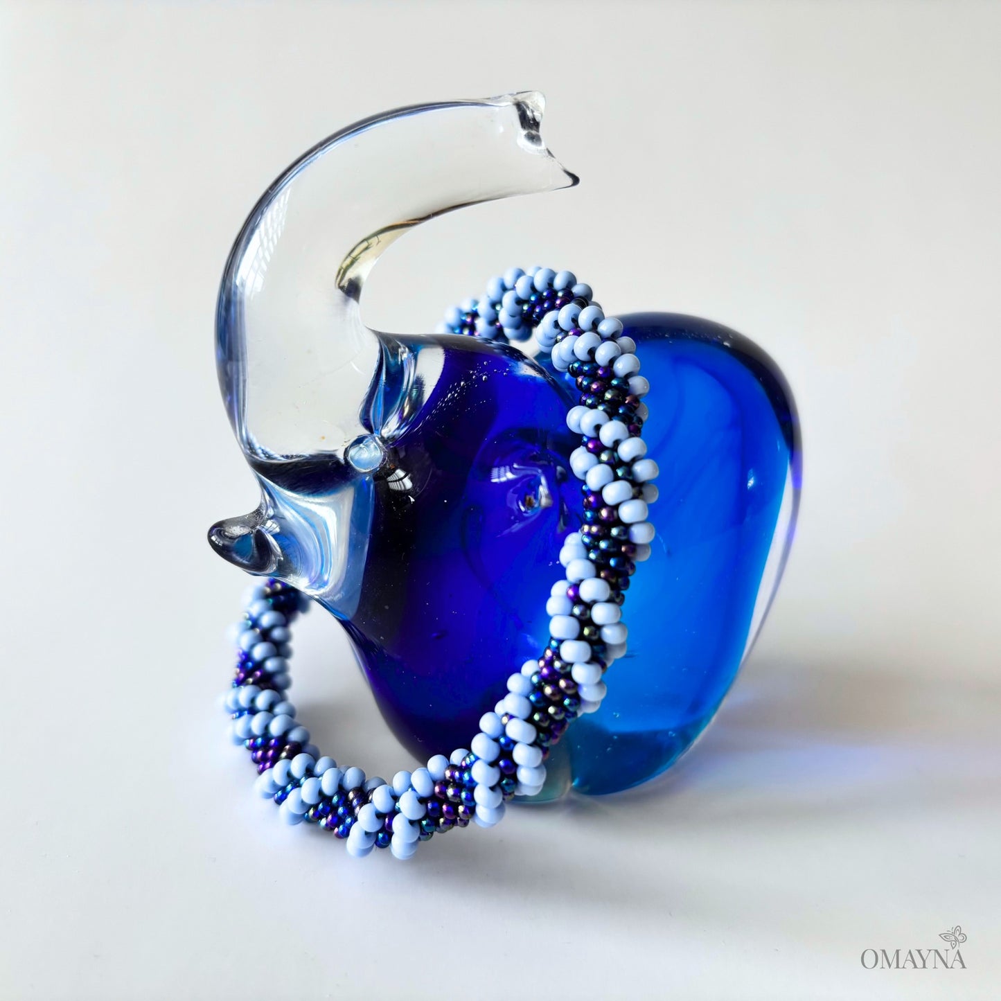 A braceelet in blue tones on a glass elephant