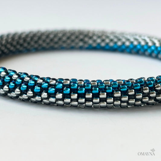 Close-up of a beaded bracelet with blue and silver beads on a white background
