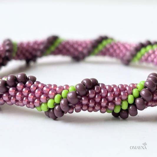 Detail of beaded bracelet in purple and green