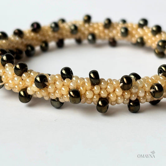 Beaded bracelet with brown iris and beige beads on a white background