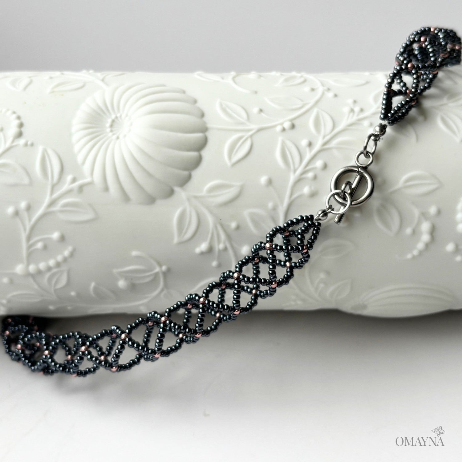 An Omayna necklace in hematite with pink gold accents