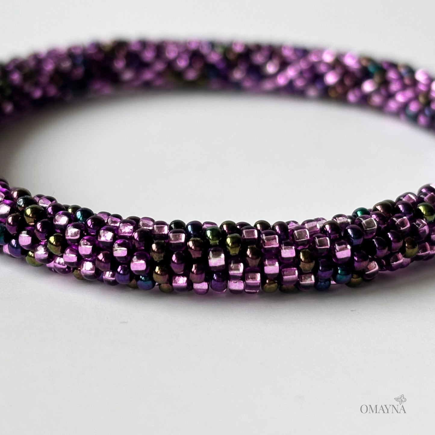 Close-up of a bracelet in purple tones on a white surface