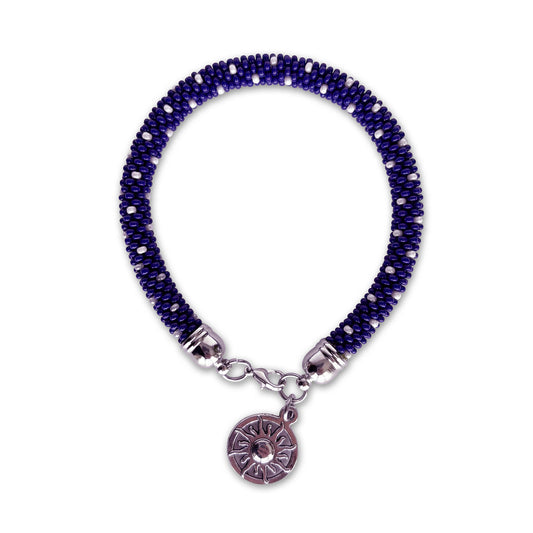 Cobalt blue beaded bracelet with a silver charm on a white background