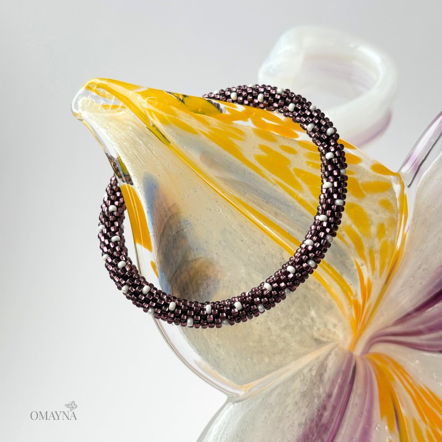Purple beaded bracelet on a decorative glass element