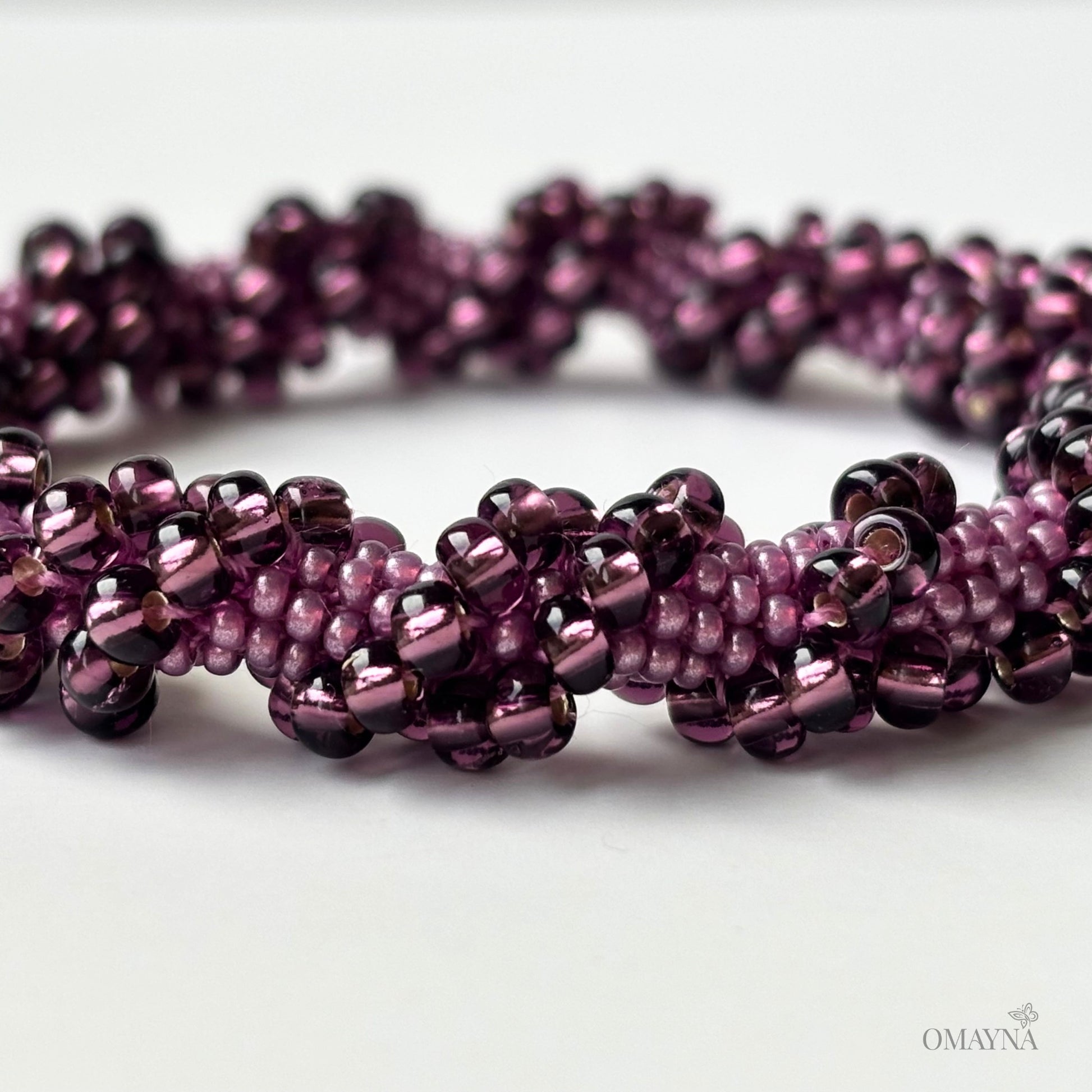 Close-up of a purple beaded bracelet on a white background