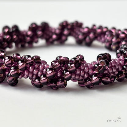 Close-up of a purple beaded bracelet on a white background