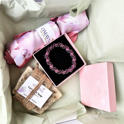 Gift set with soap, bracelet, and pink scarf - packaging on a light background