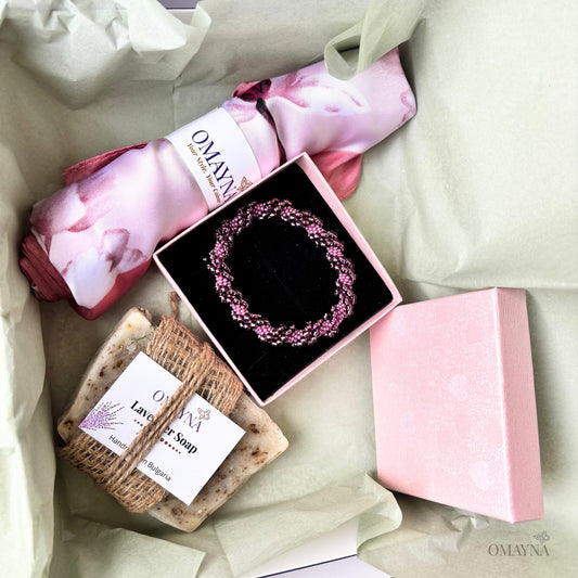 Gift set with soap, bracelet, and pink scarf - packaging on a light background