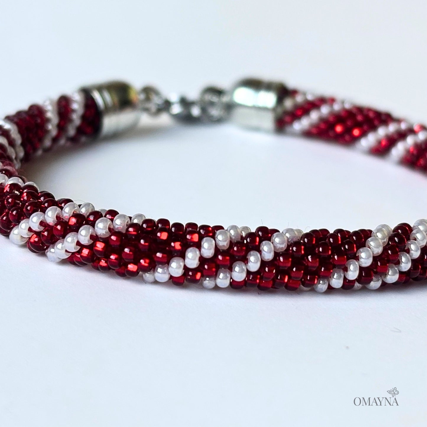 Beaded bracelet with red and pearl beads on a white background