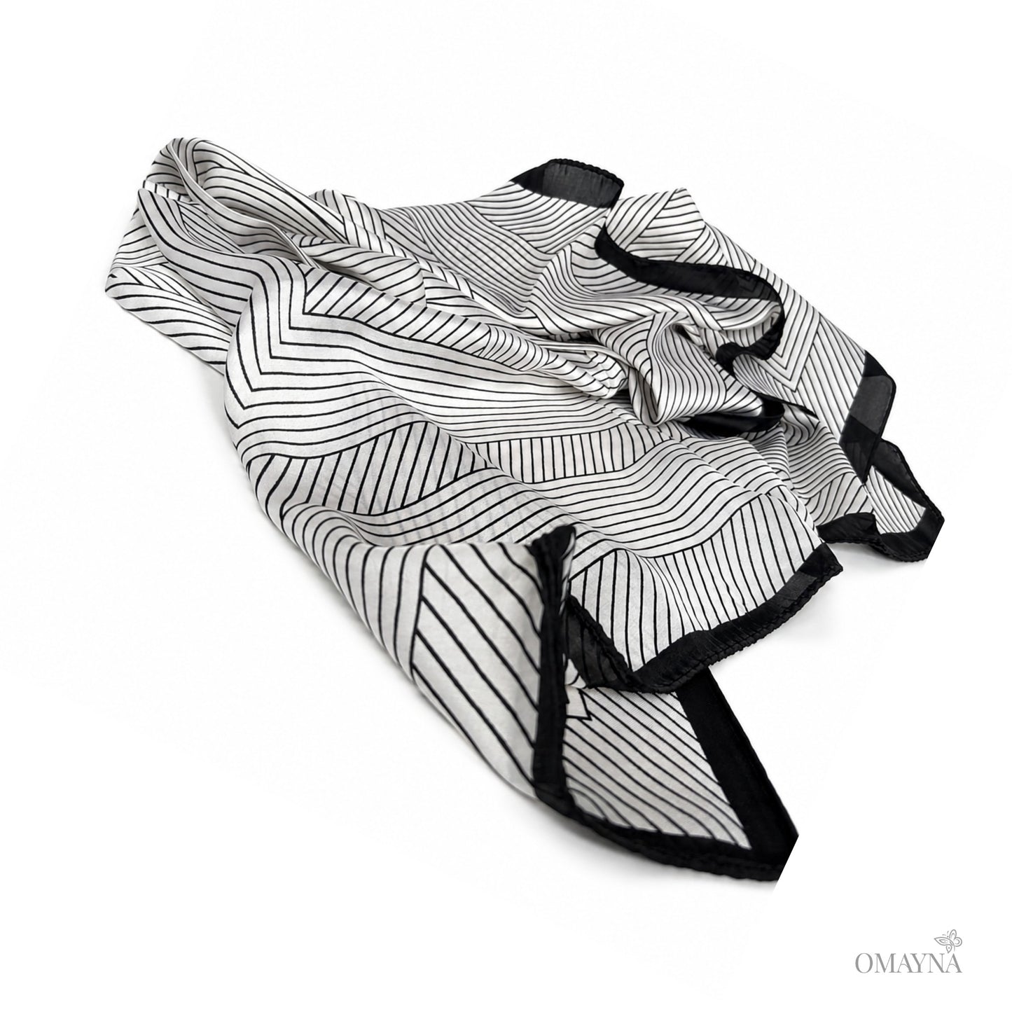 Black and pearl patterned silk scarf on a white background
