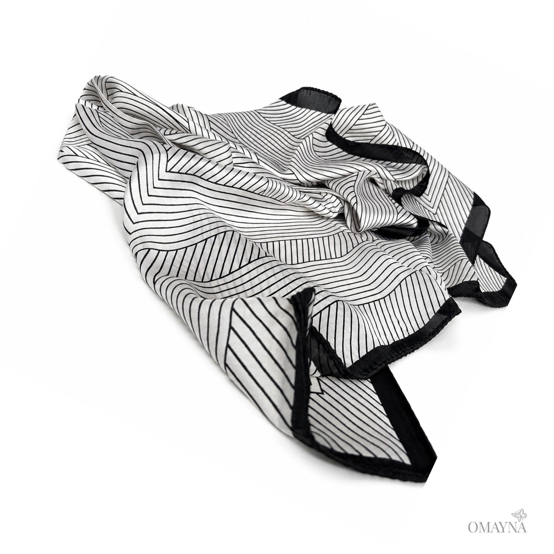 Black and pearl patterned silk scarf on a white background