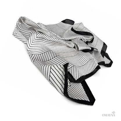 Black and pearl patterned silk scarf on a white background