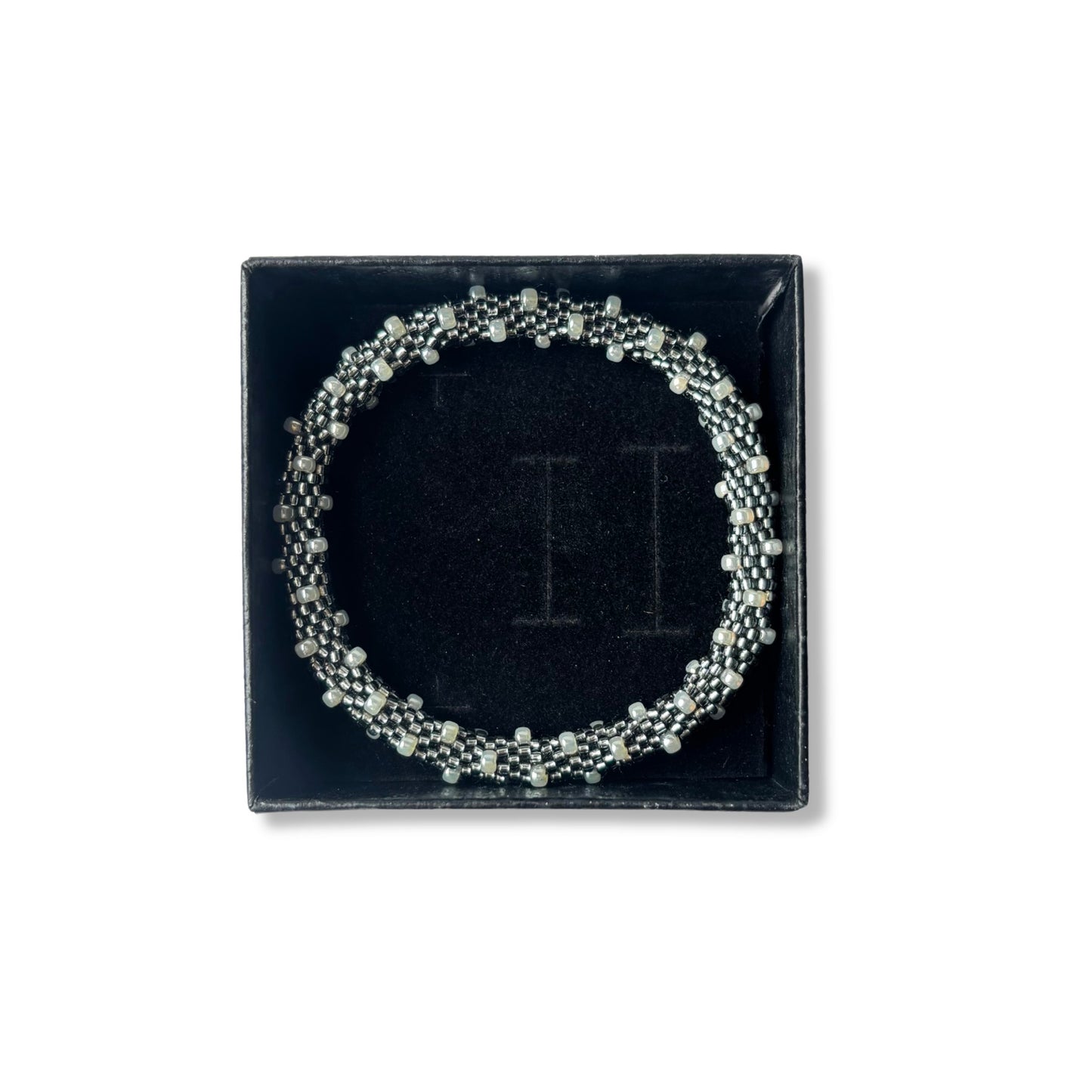 Grey and pearl beaded bracelet on a black box