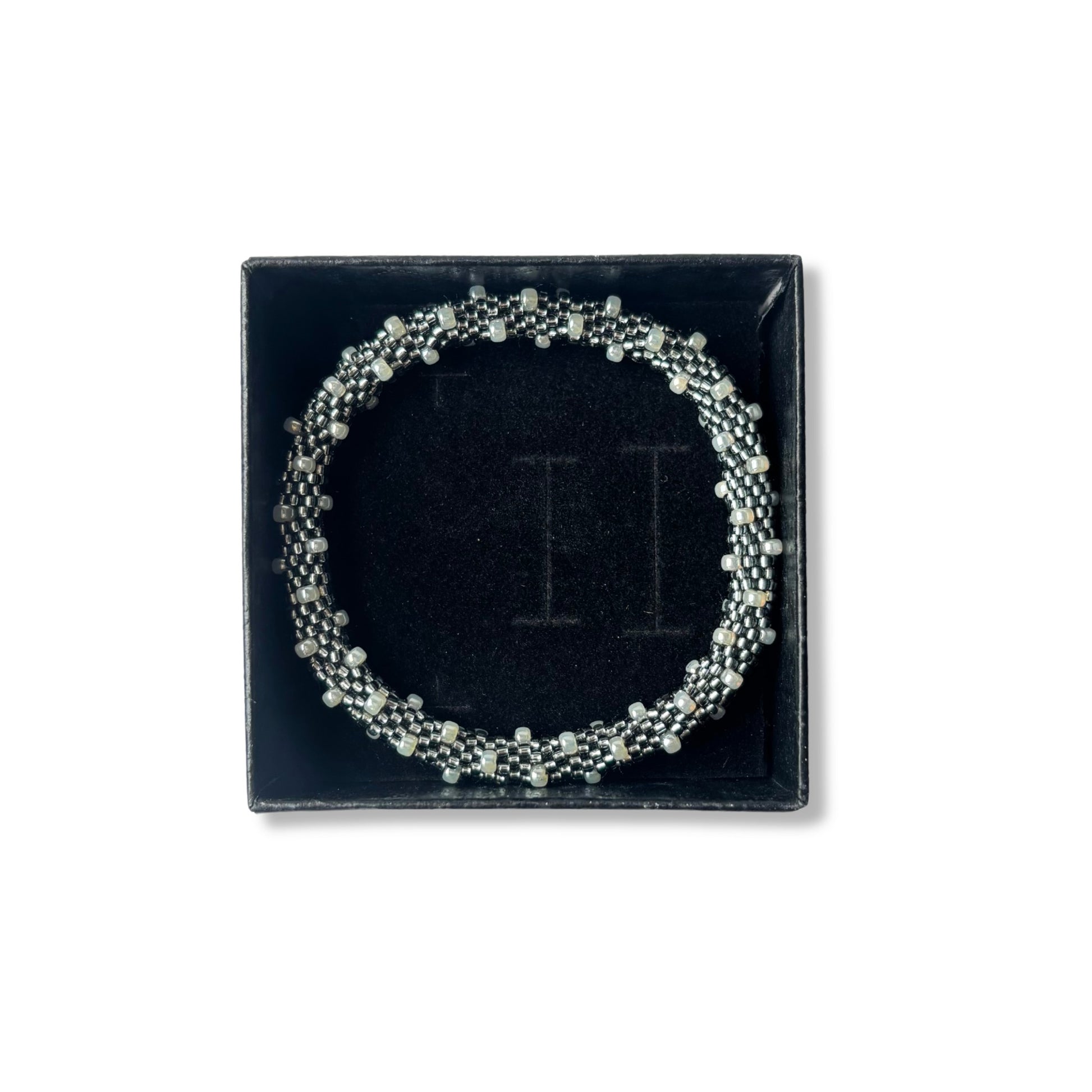 Grey and pearl beaded bracelet on a black box