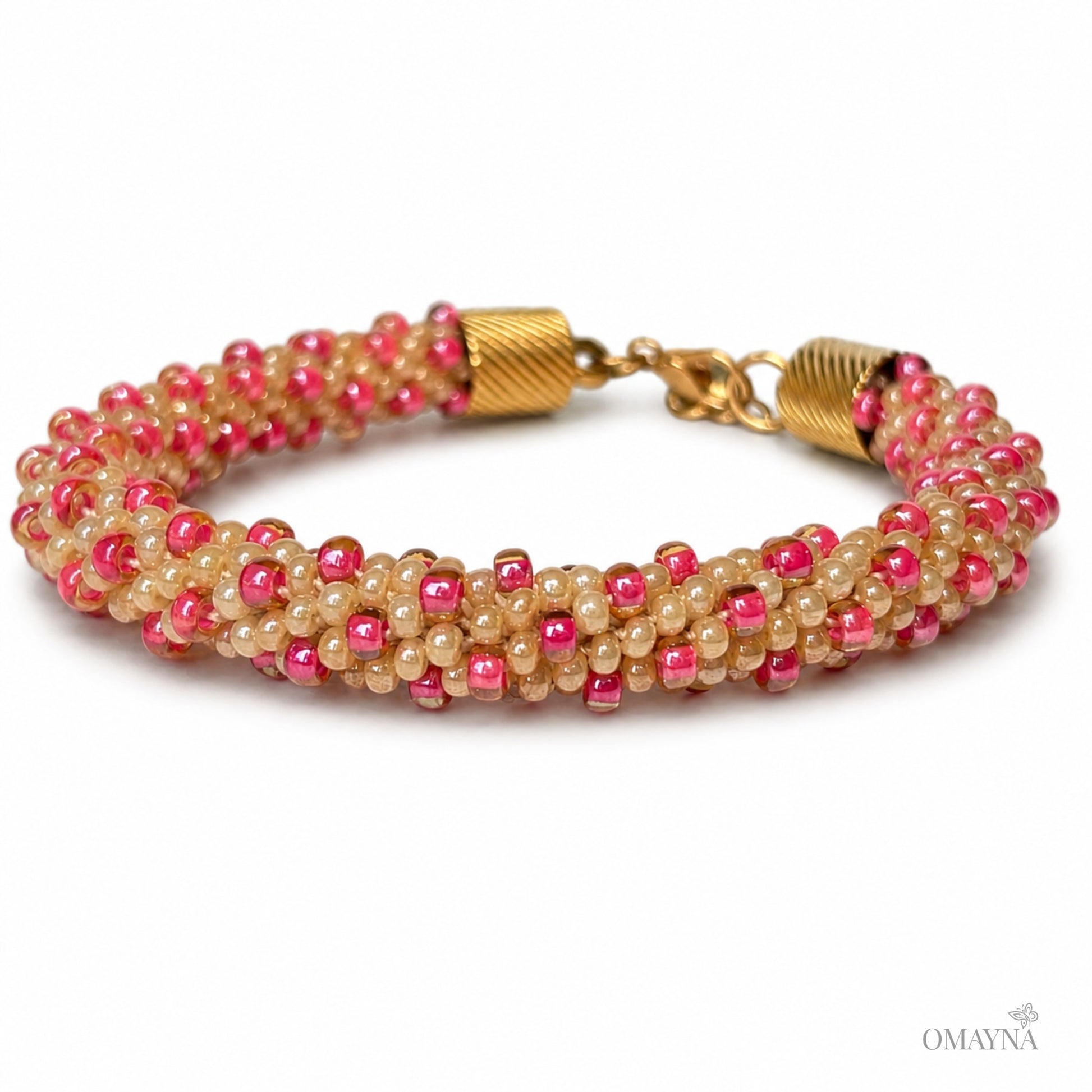 Beaded bracelet with pink and beige, gold-tone lobster clasp on a white background