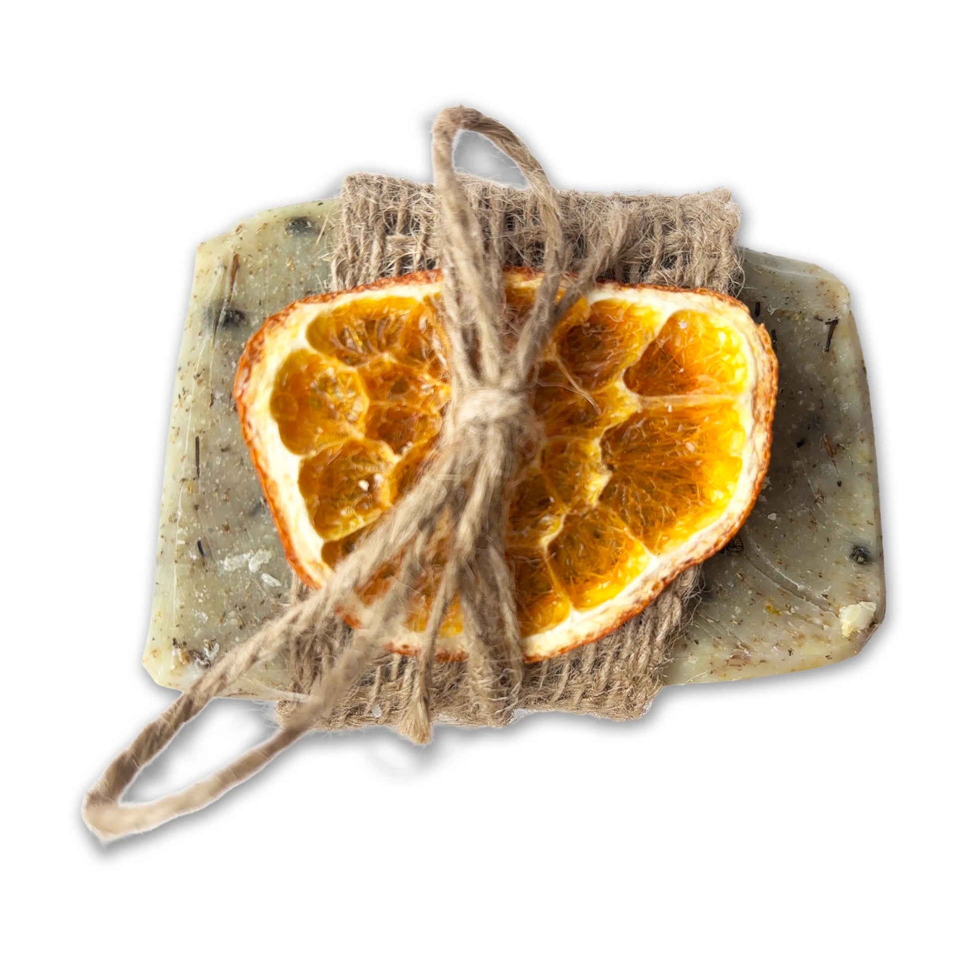 Dried orange slices tied with twine on a bar of handmade chamomile soap