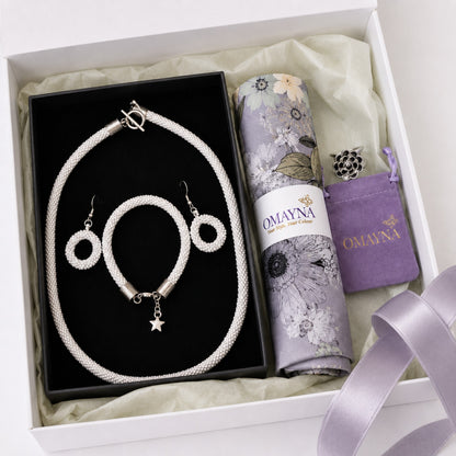 Jewelry set with a necklace, bracelet, and earrings in a box, featuring Omayna branding.