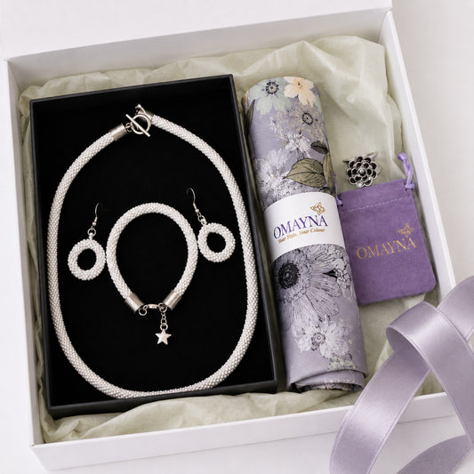 Jewelry set with a necklace, bracelet, and earrings in a box, featuring Omayna branding.