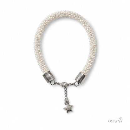 Pearl bracelet with silver beads and a star charm on a white background