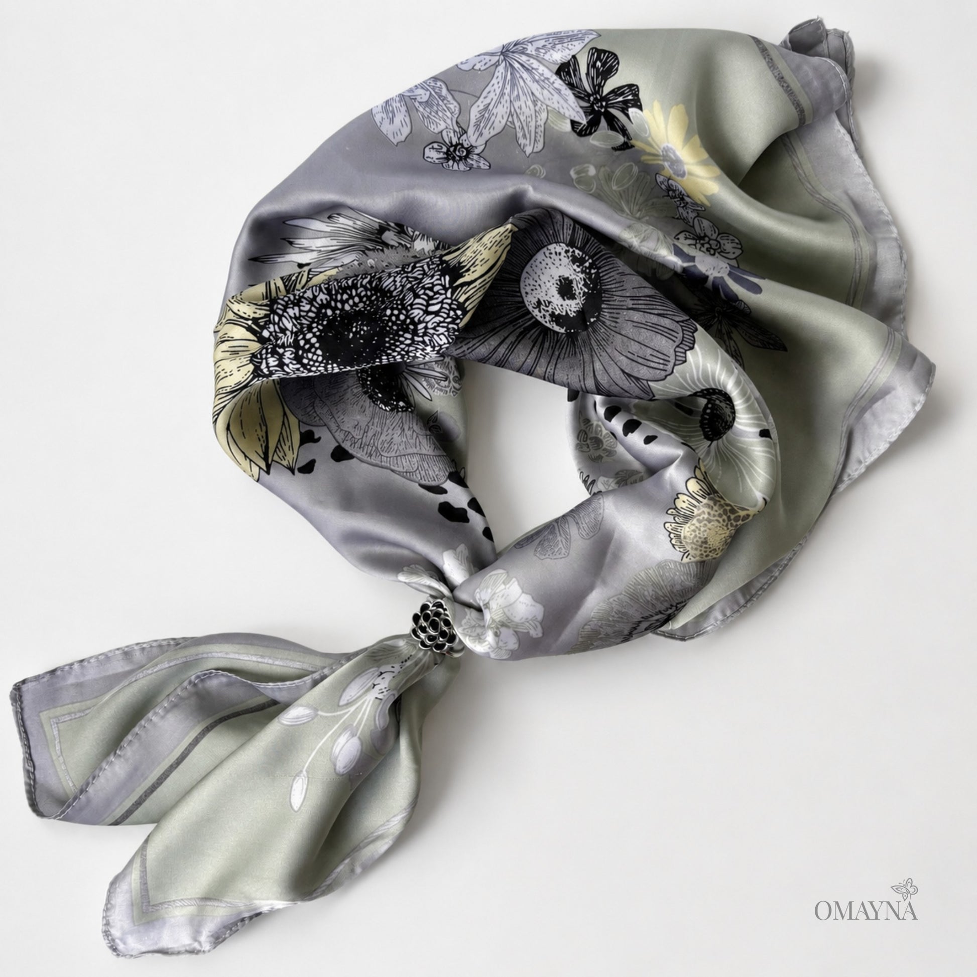 Decorative scarf with floral pattern and scarf ring on a white background, featuring the brand 'OMAYNA'.