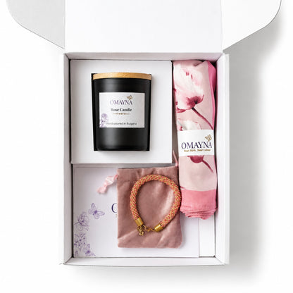 Gift set with a candle, bracelet, and scarf in a box, featuring Omayna branding. Pink and beige