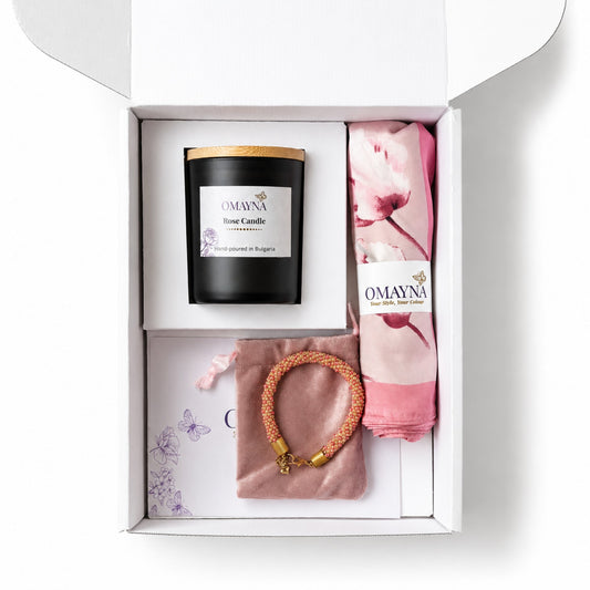Gift set with a candle, bracelet, and scarf in a box, featuring Omayna branding. Pink and beige