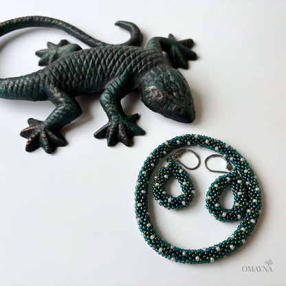 Bronze lizard figurine with a bracelet and earrings on a white background