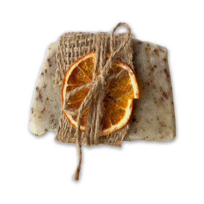 A lavender soap bar with orange slices and twine on a white background