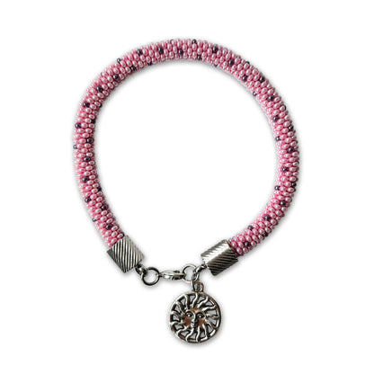 Lina beaded bracelet in soft pink tones with purple accents and sun charm on a white background