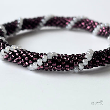 Beaded bracelet with purple and white beads on a white background - detail