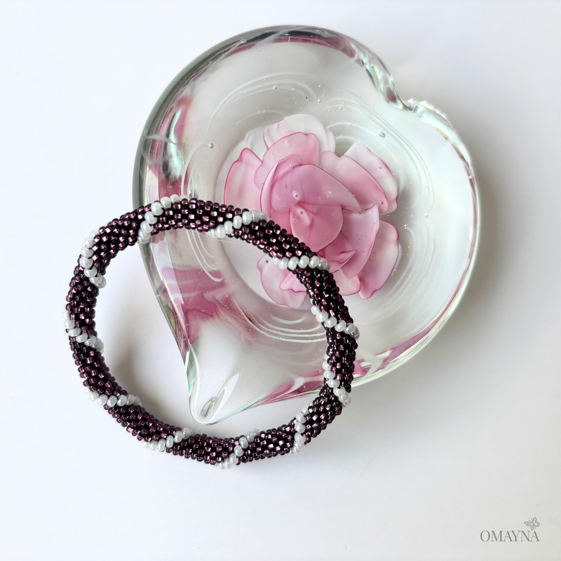 Lora beaded bracelet  on a heart-shaped glass dish with a pink flower design