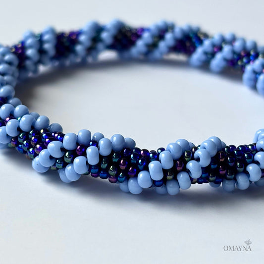 Close-up of a blue bracelet, light blue and blue iris, plain background