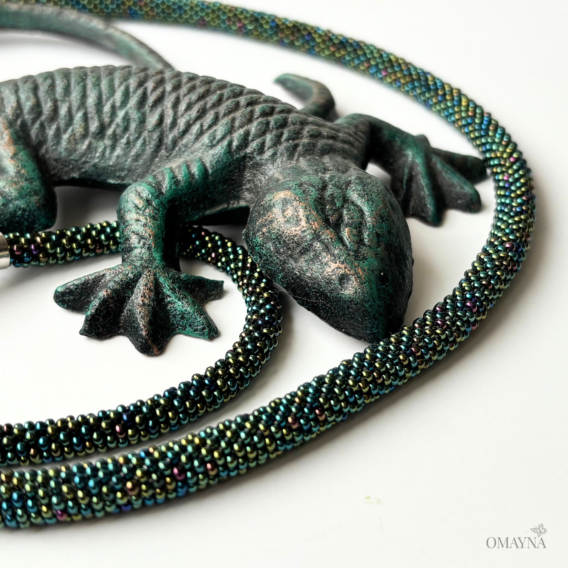 Mel beaded set of bracelet and necklace with magnetic clasps with a chameleon on a white background, colour green Iris