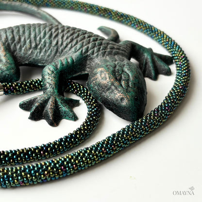 Mel beaded set of bracelet and necklace with magnetic clasps with a chameleon on a white background, colour green Iris