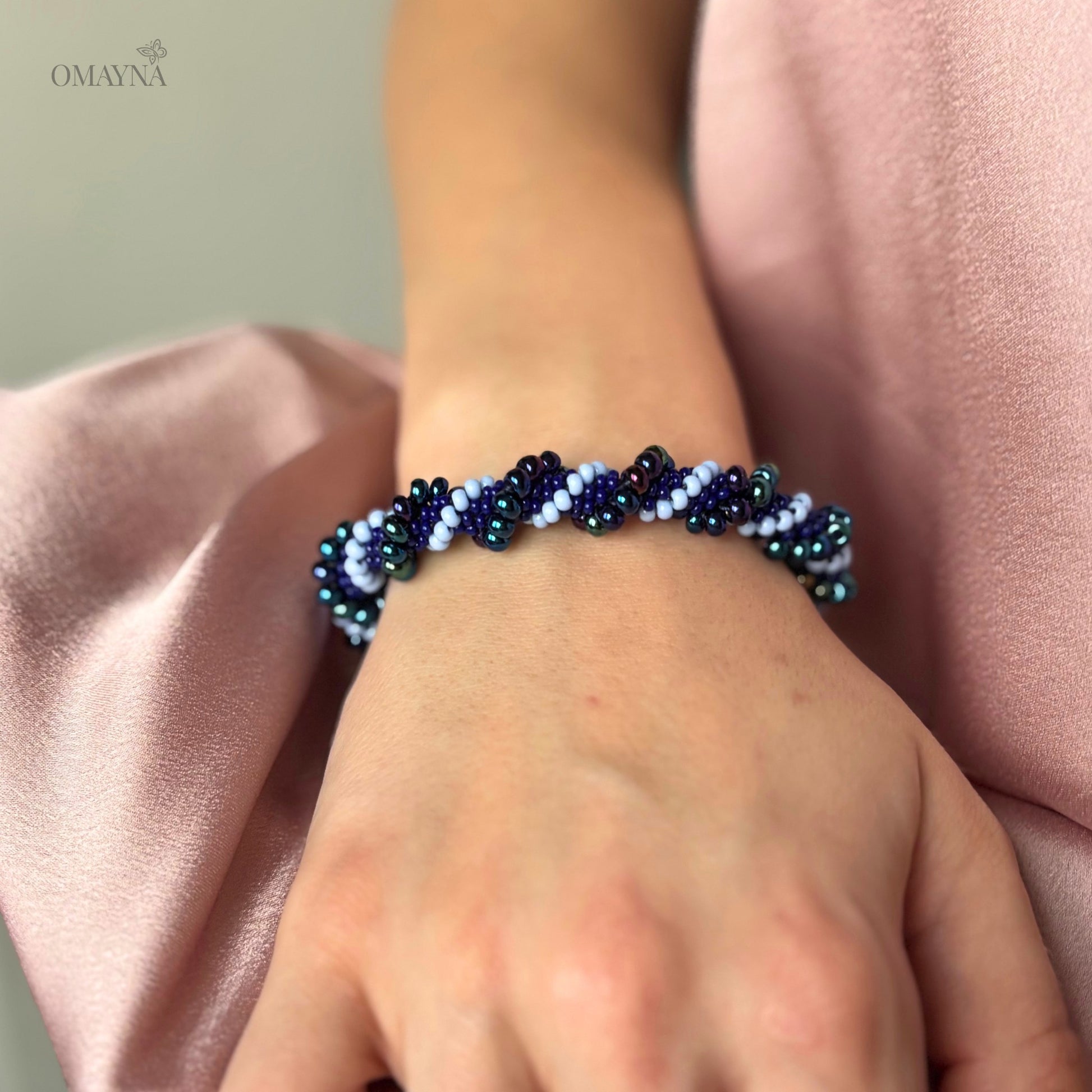 Mia beaded bracelet in purple and blue tones worn on wrist