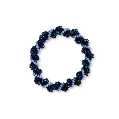 Beaded bracelet with different shades of purple beads on a white background