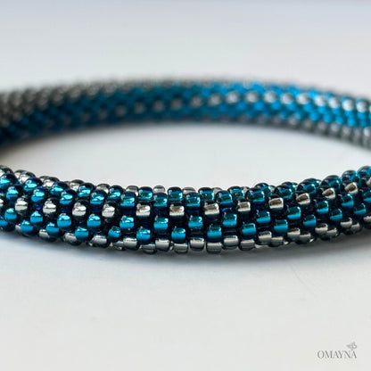 Close-up of a blue and silver beaded bracelet on a light background
