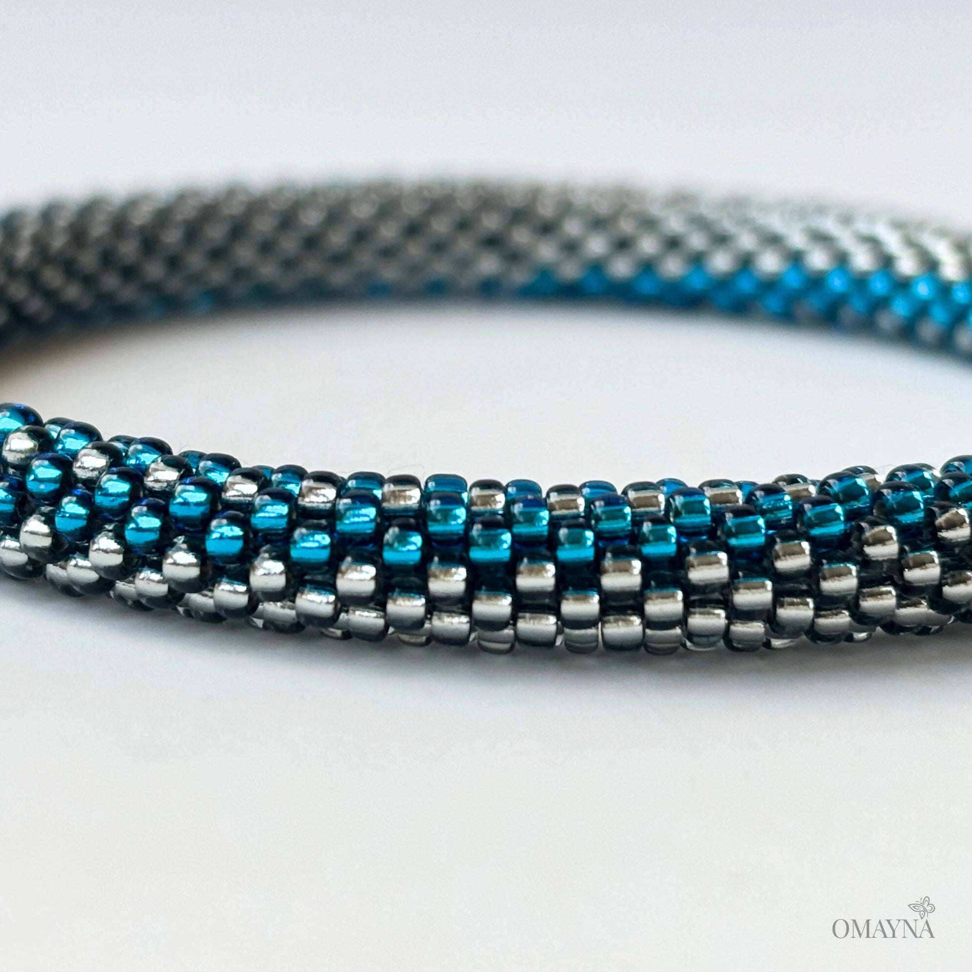Close-up of a beaded bracelet with blue and silver beads on a white background