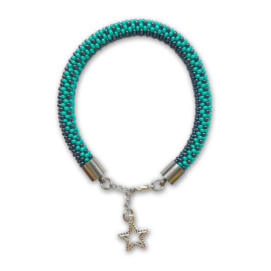 Hematite and green beaded bracelet with a star charm on a white background