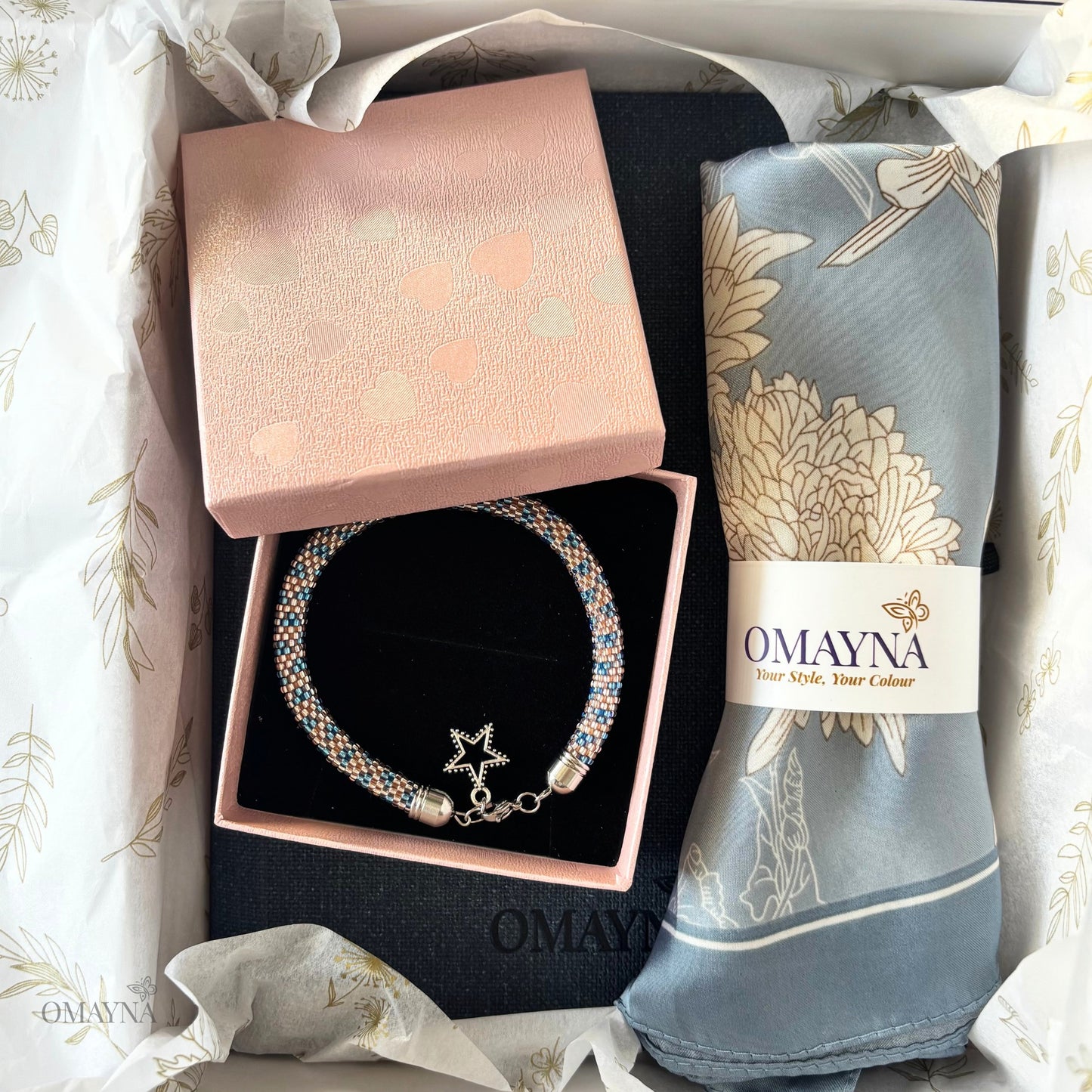 Bracelet and silk scarf with 'Omayna' branding in a gift box.