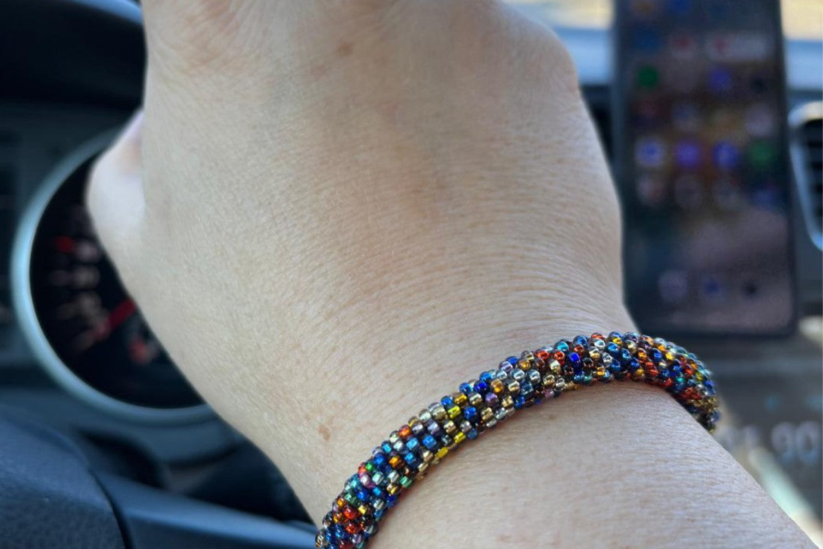 Omayna bracelet on a hand sturring a driving wheel