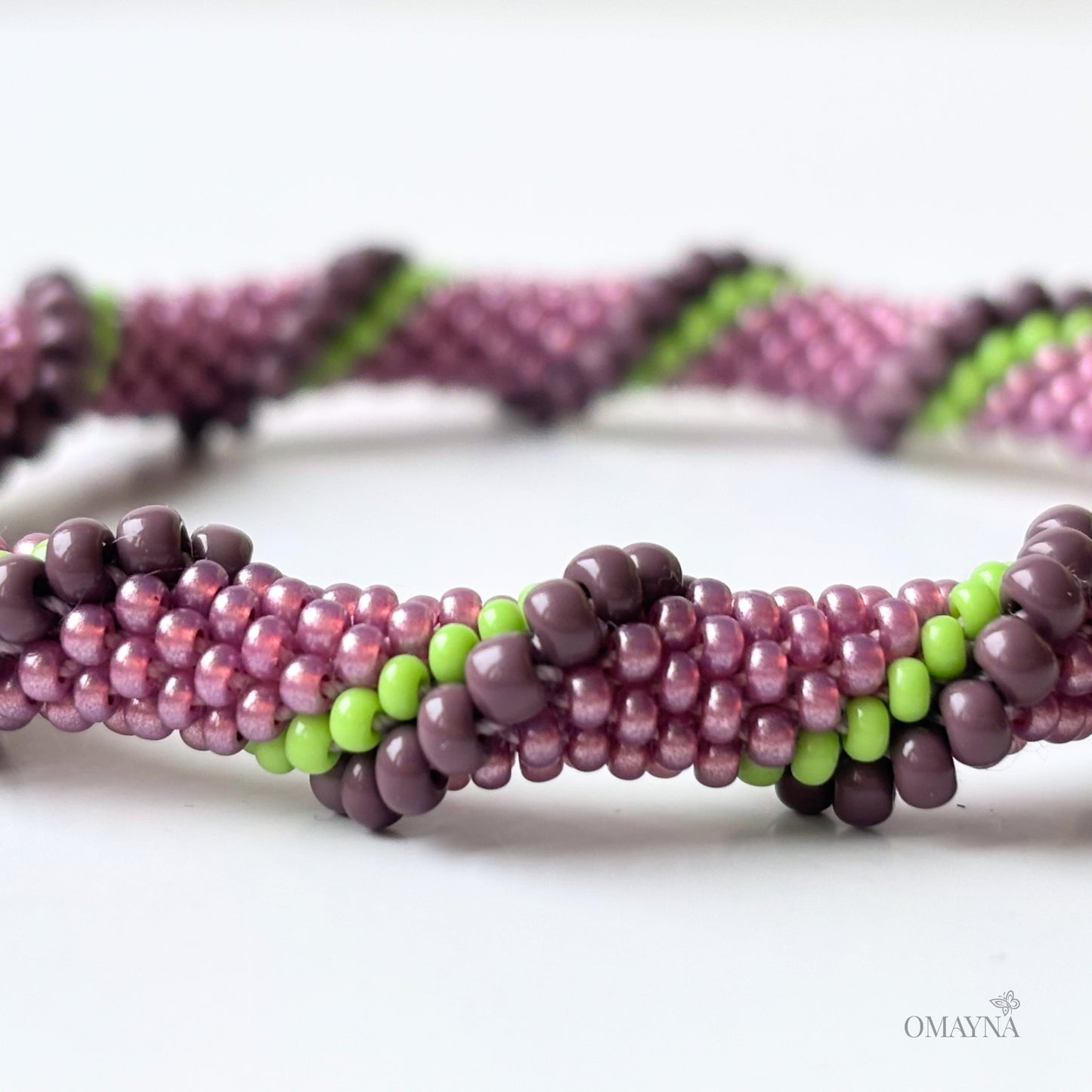 Detail of beaded bracelet in purple and green