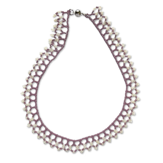 Una beaded necklace in soft purple and cream tones on a white background