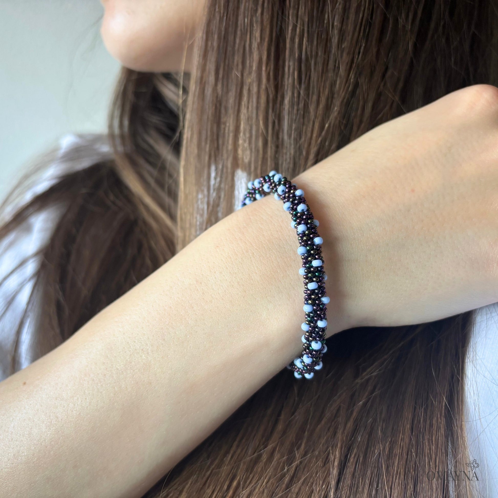Bracelet in light blue & shades of blue on a young woman hand