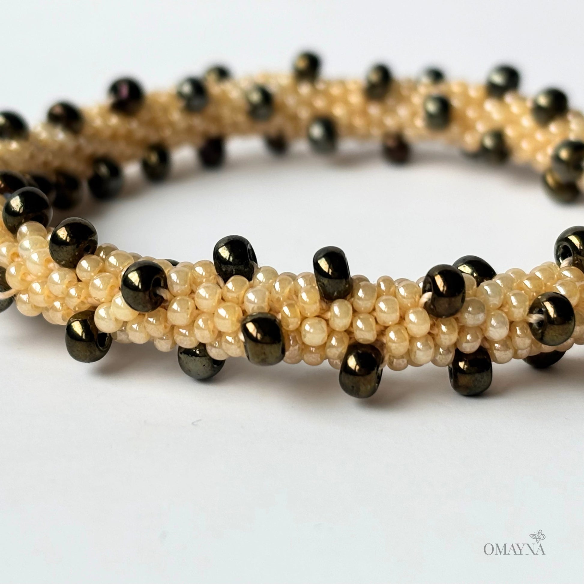 Beaded bracelet with brown iris and beige beads on a white background