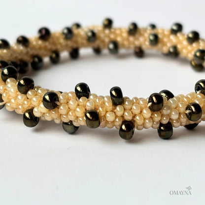 Beaded bracelet with brown iris and beige beads on a white background